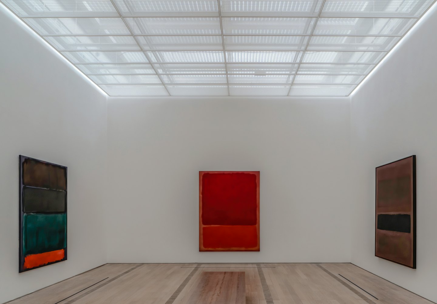 Three abstract paintings displayed on white gallery walls.