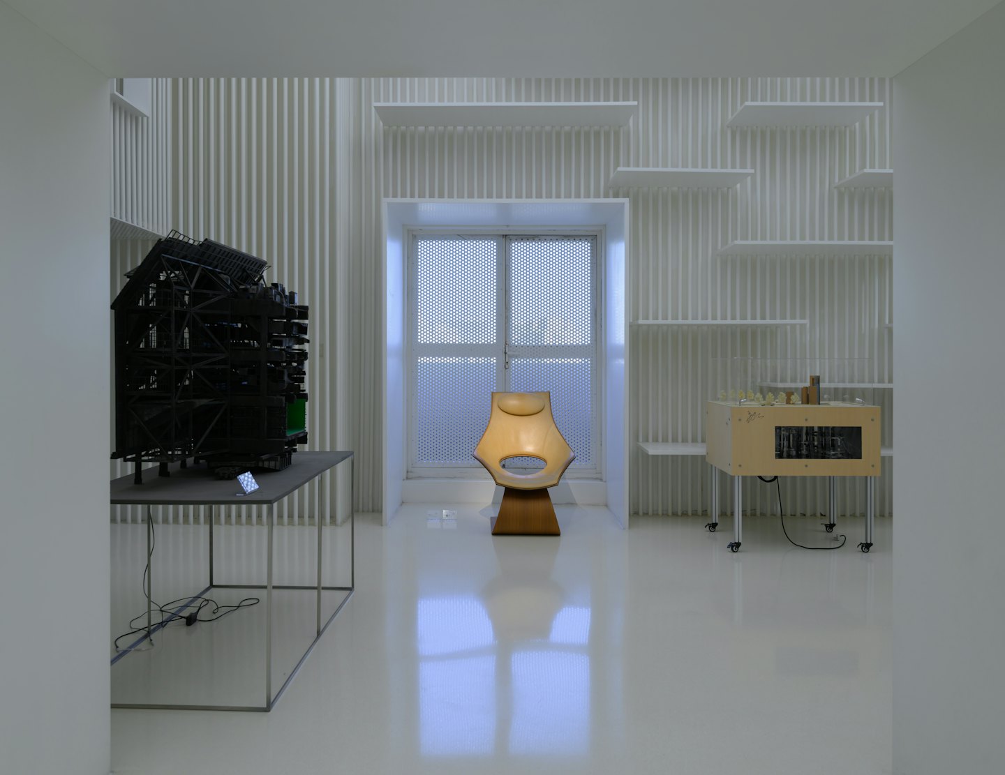 Modern sculptures and furniture displayed in a bright gallery space.